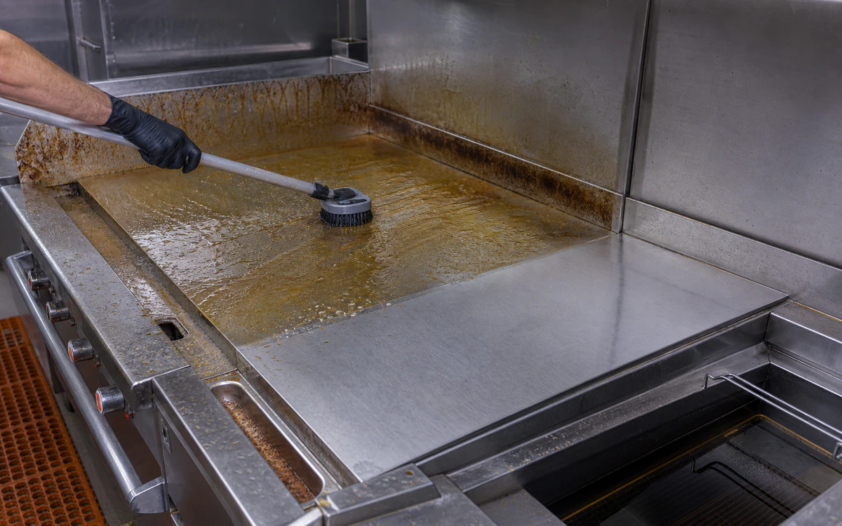 Wet softened grease being agitated from an empty commercial cookline during shutdown